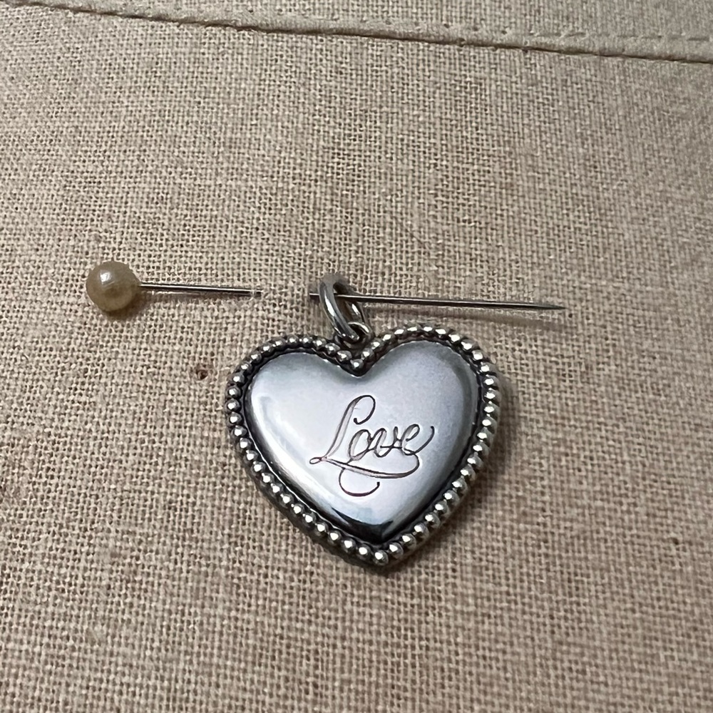 Tiffany & Co. “Love” sterling silver heart charm.
